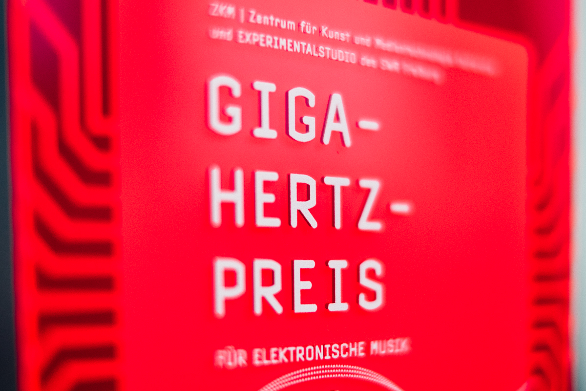 Roter Plakette, auf der mit weißer Schrift "Giga-Hertz-Preis" steht