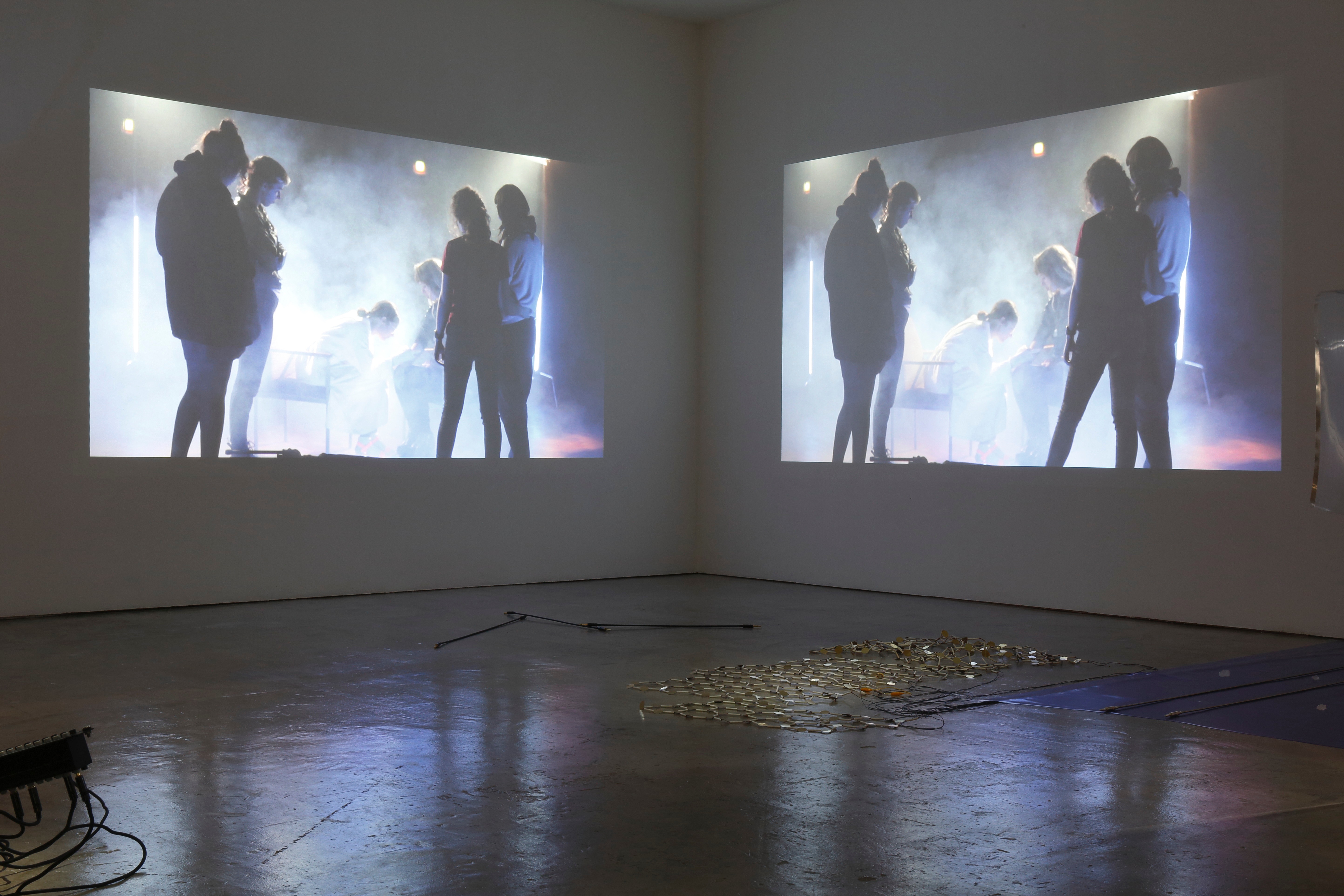Doppelte Installation mit Menschen in Nebel, projieziert an Wand