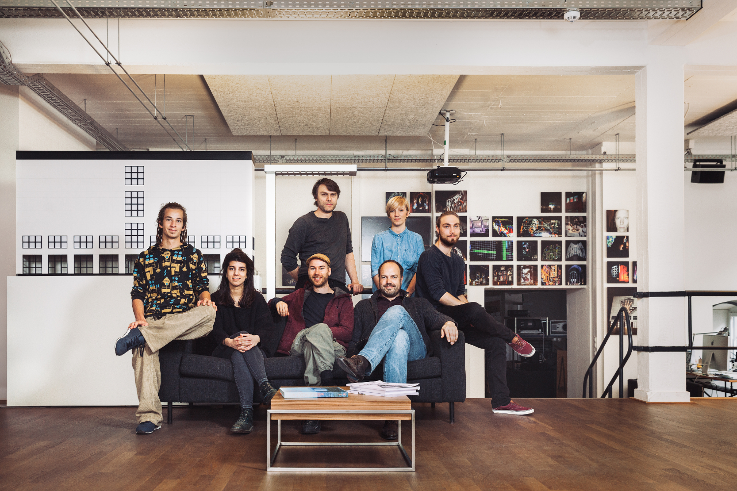 Das Künstlerkollektiv sitzt auf einem Sofa in ihrem Studio