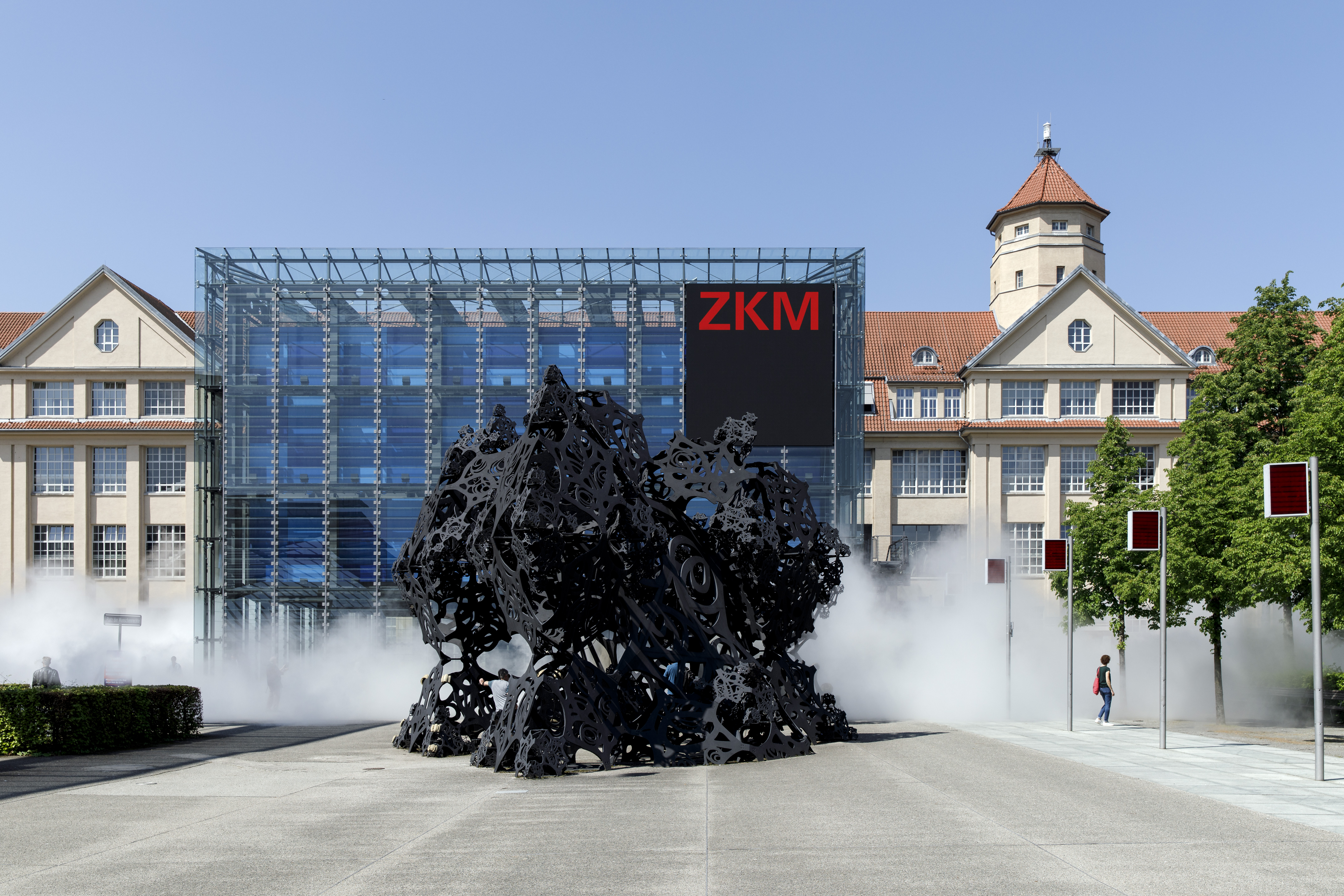 Zu sehen ist der Eingang des ZKM sowie der Kubus mit einer sich leicht anmutenden Nebelschwade.