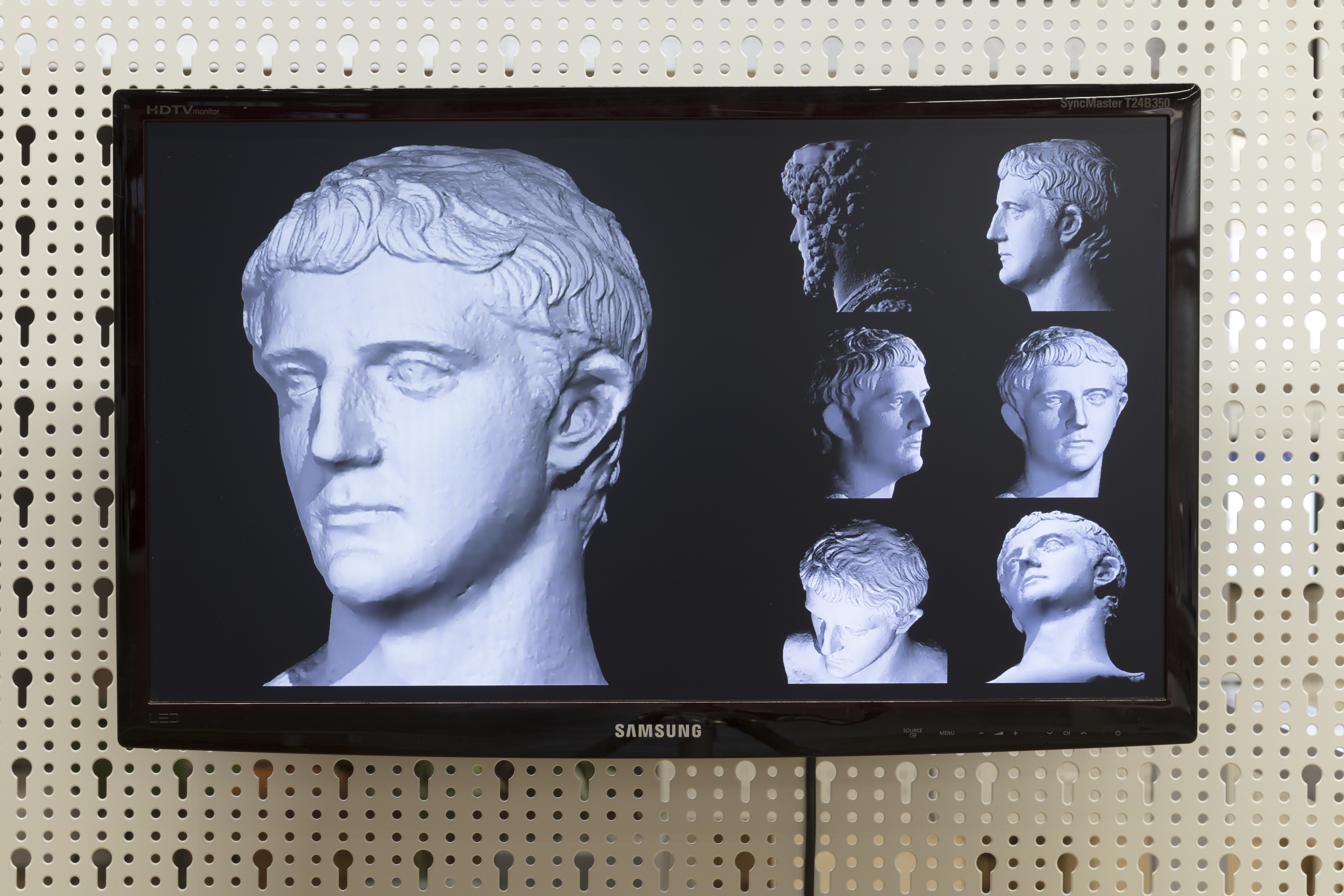Different views of an antique statue on a flat screen monitor.