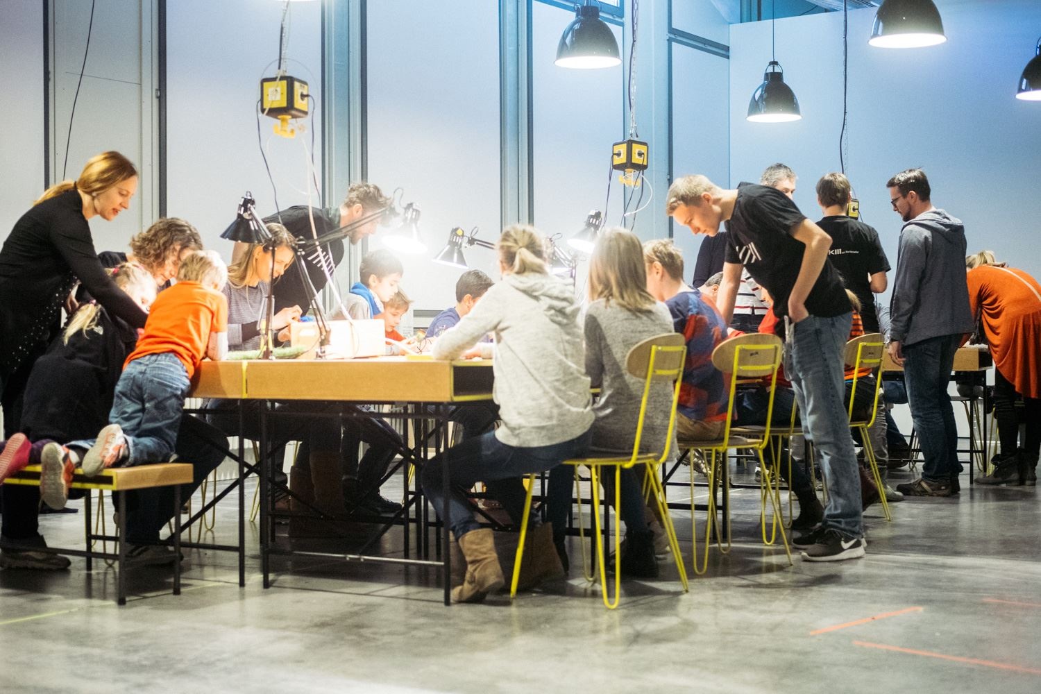 Menschen sitzen an einem erleuchteten Tisch und arbeiten gemeinsam