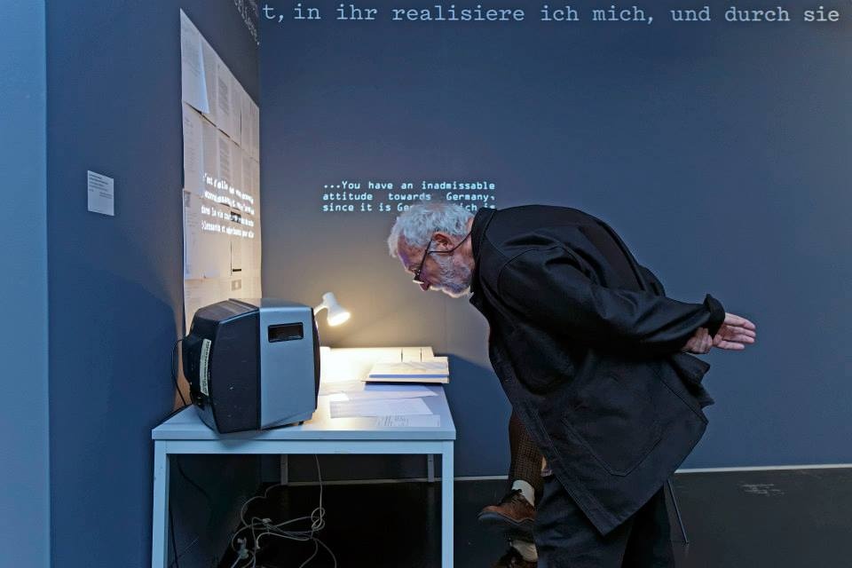 Ein Mann liest vor einem kleinen Bildschirm die Beschreibung