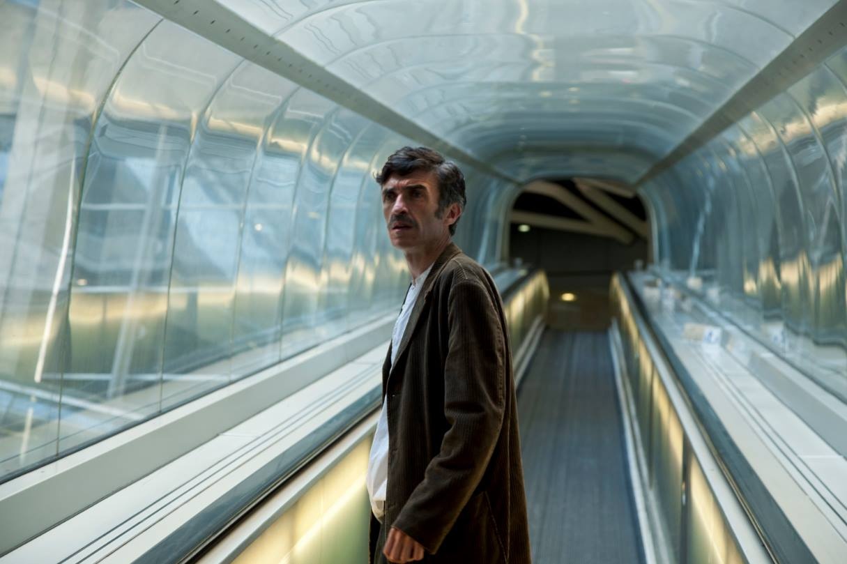 Ein Mann steht in einer Art Tunnel, er sieht verwirrt aus