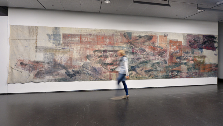 A woman walks by a painting