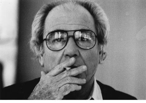 Black-and-white photograph: Jean Baudrillard smokes a cigarette