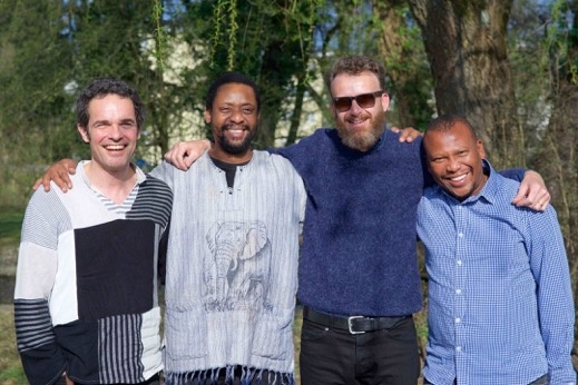 Das Bild zeigt die vier strahlenden Mitglieder von Bänz Oester & The Rainmakers