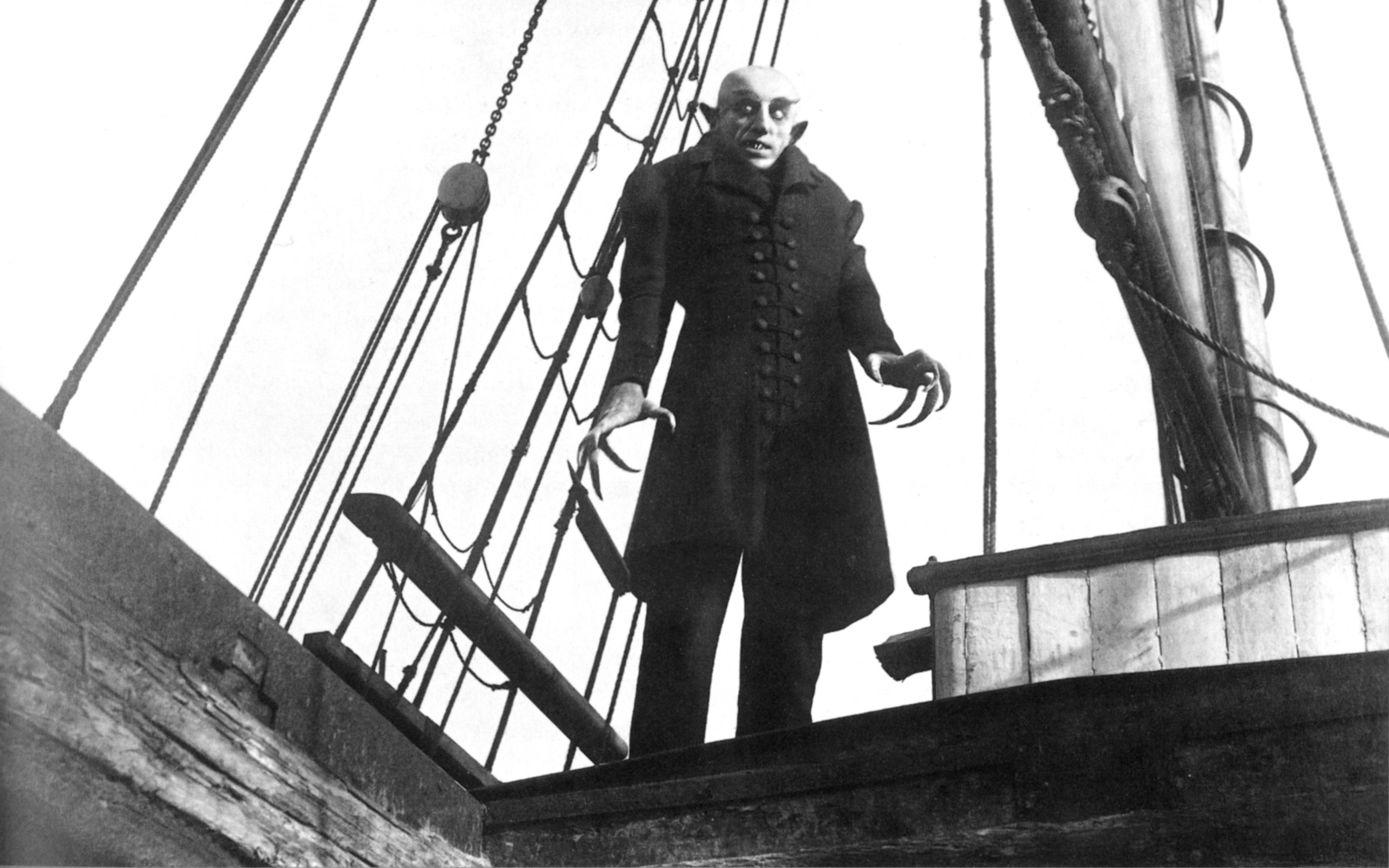 Ein Mann mit Krallenhänden steht auf einem Schiff