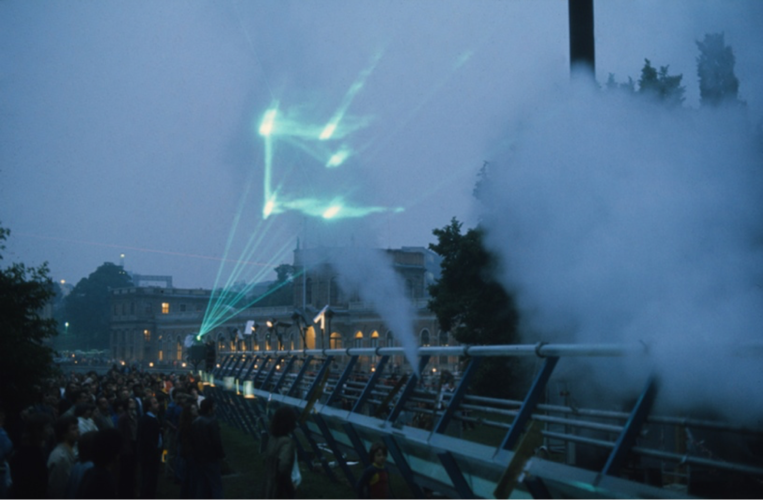 Das Bild zeigt eine grüne Lasershow mit Publikum 