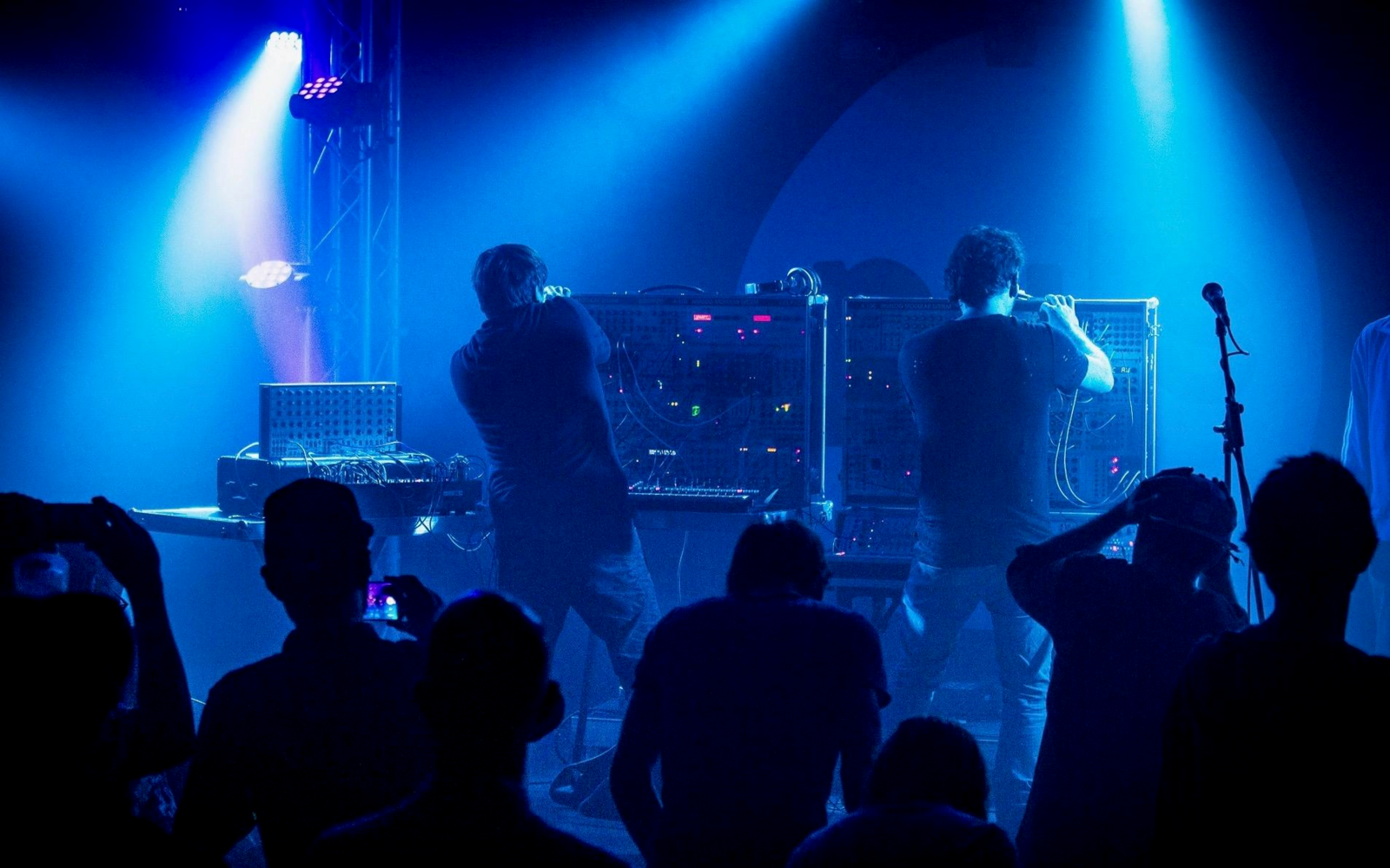 Zwei Musiker stehen vor elektrischen Instrumenten auf der Bühne