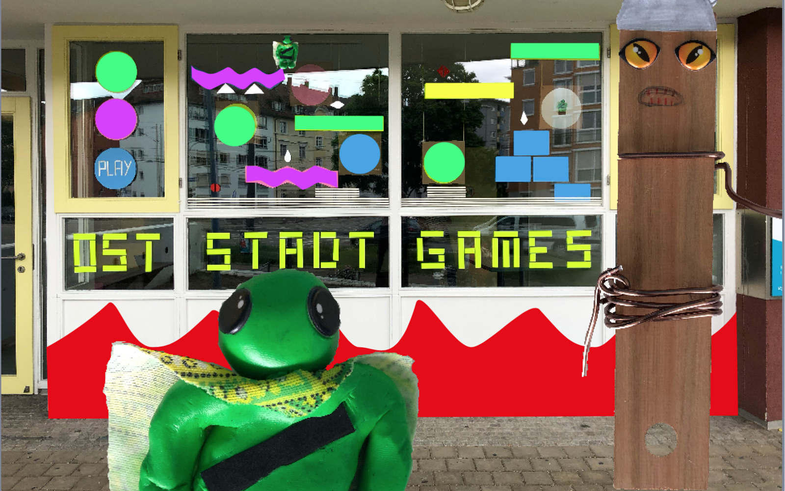 Außenansicht eines Fensters mit Basteleien und der Aufschrift »Oststadt Games«, im Vordergrund weitere Bastelarbeiten