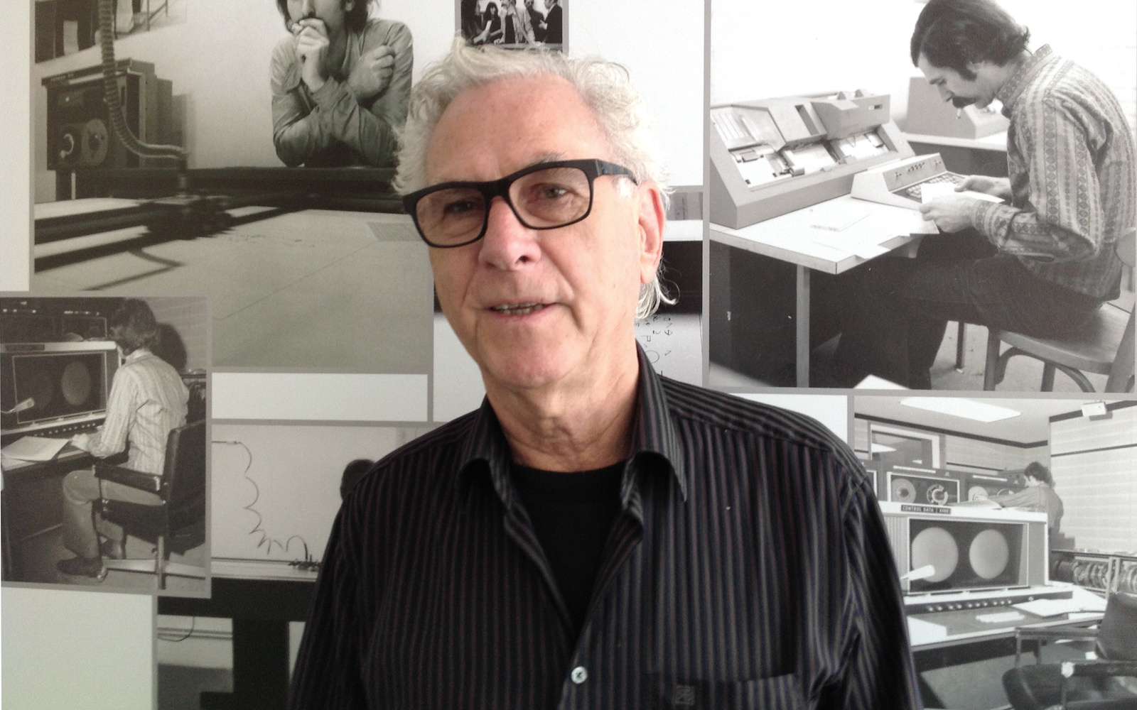 Porträt des Künstlers Manfred Mohr. Im Hintergrund Schwarzweißfotos, die den Künstler im Jahr 1971 zeigen.