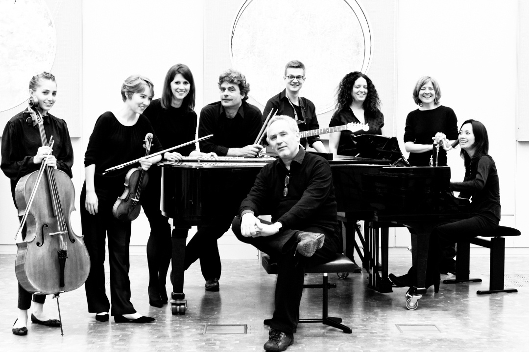 Zu sehen ist das »Ensemble Experimental« bestehend aus acht Personen. Eine Person sitzt vor einem Klavier und der Rest steht dahinter. Das Bild ist schwarz-weiß.