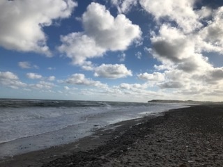Das Bild zeigt einen Strand unter wolkigem Himmel.