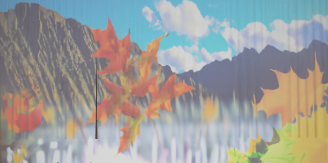 On display is the installation "Electrify Me, Baby" (2024) by Anne Duk Hee Jordan. A woman stands in front of a yellow object. A mountain and red leaves can be seen in the background