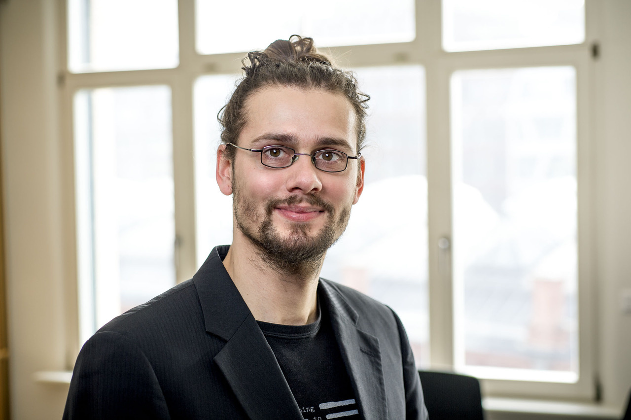 Portrait Rainer Rehak vor hellem Hintergrund