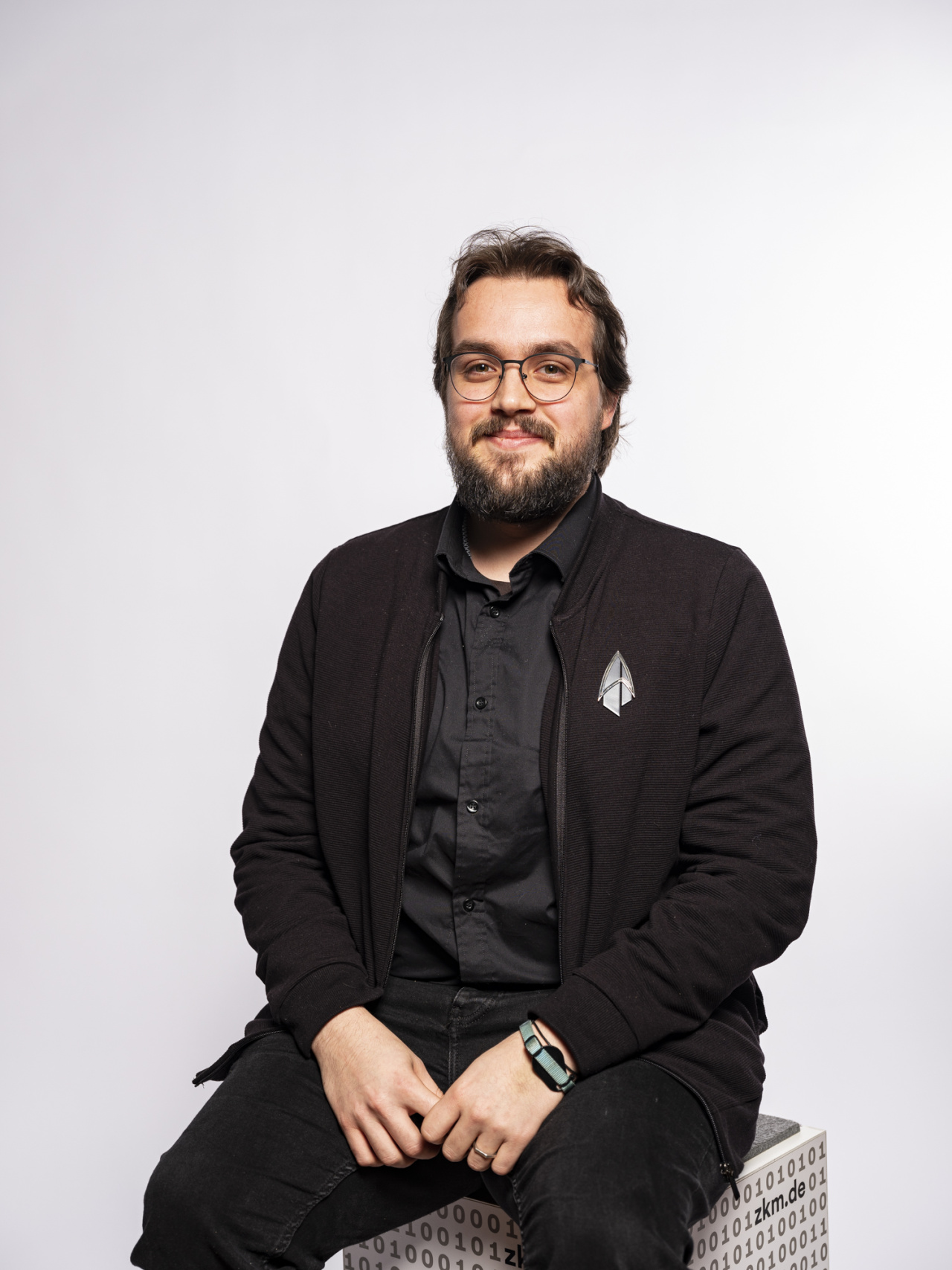 Ein sitzender dunkelhaariger junger Mann