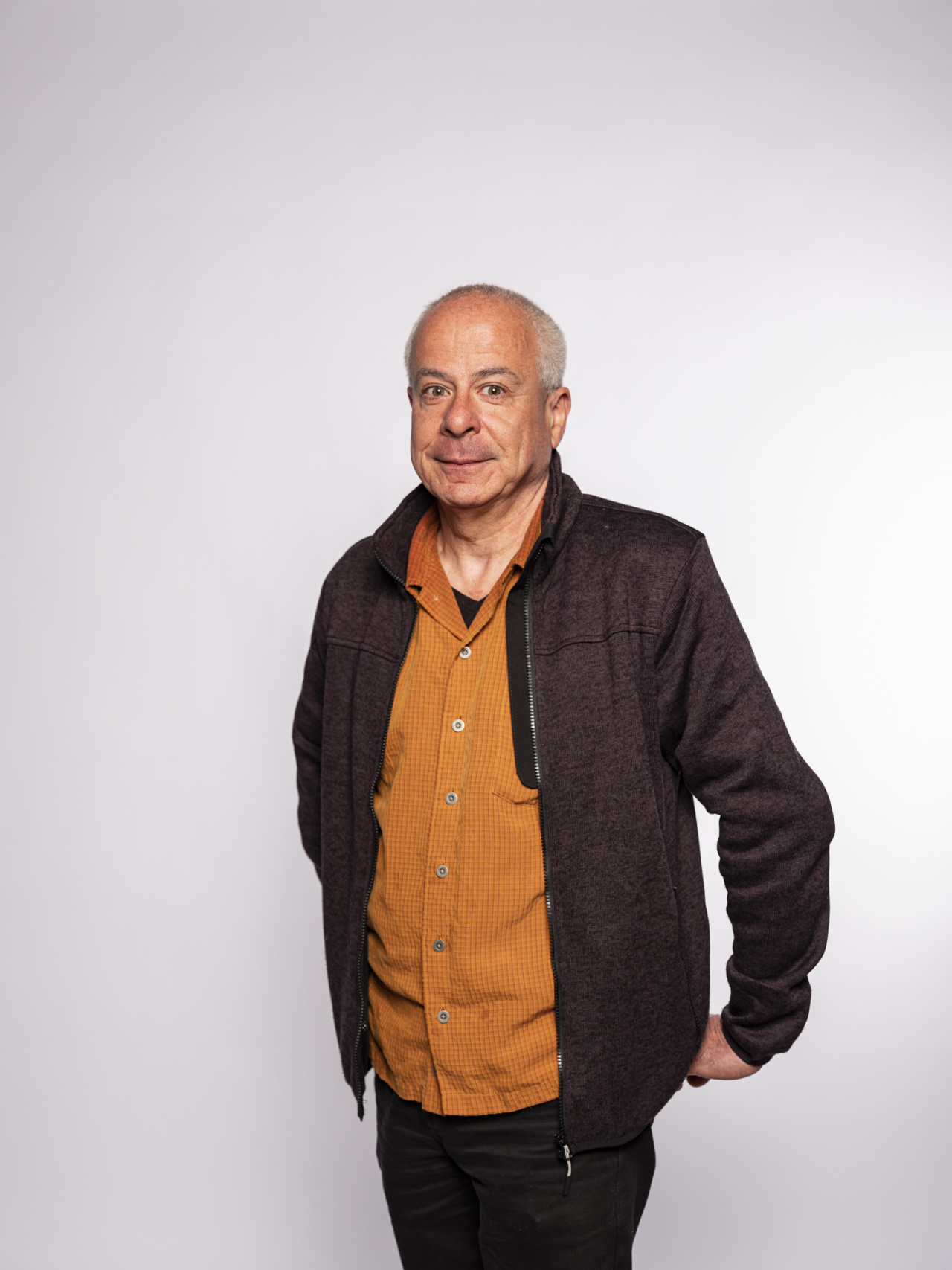 stehender Mann mit orangenem Hemd 