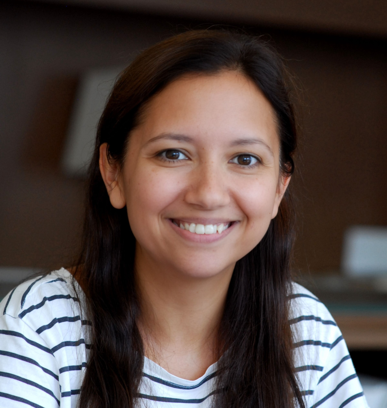 A smiling young woman with long black hair.