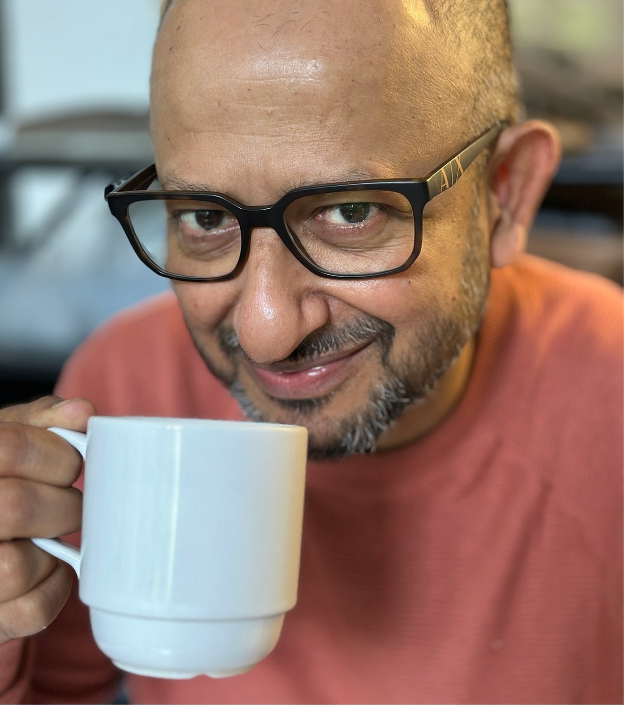 You can see a portrait photo of a person holding a cup in their hand.