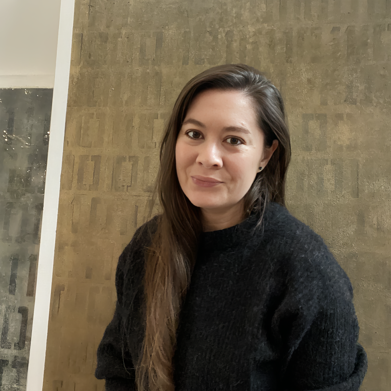 Portrait photograph of a person in front of a wall.