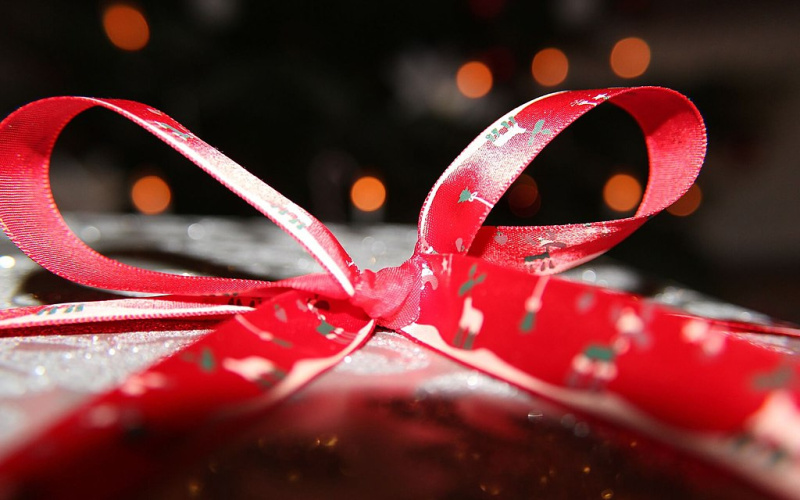 Foto eines Weihnachtsgeschenks mit roter Schleife. 