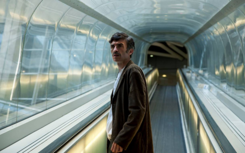 Ein Mann steht in einer Art Tunnel, er sieht verwirrt aus