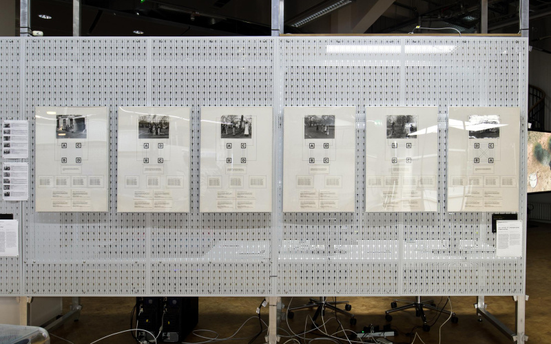 The figure shows 6 photographs with drawings hung on a white grid structure