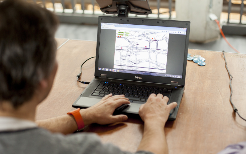 Der Blick geht über die Schulter einer Person, die vor einem Laptop sitzt