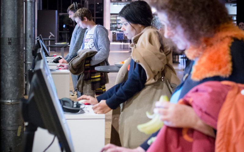 Several People standing in front of computer stations