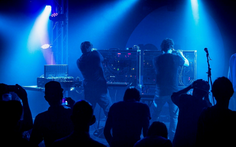 Zwei Musiker stehen vor elektrischen Instrumenten auf der Bühne