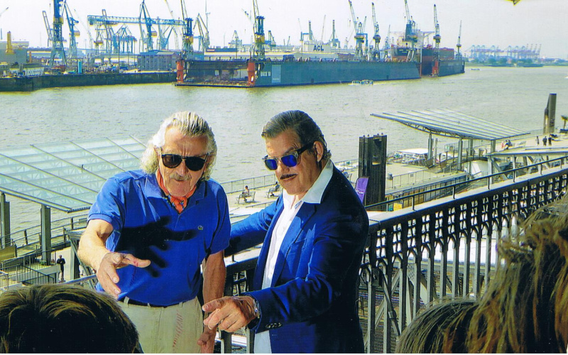 Zu sehen ist ein Bild aus dem Film »Dieter Meier – Ein Zufall«, das unter anderem Dieter Meier am Fluss zeigt