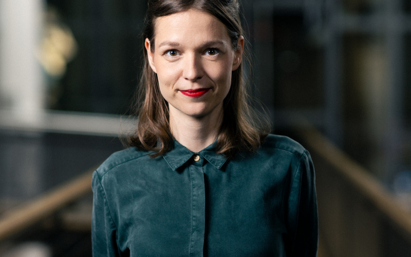 The picture shows a young woman wearing a green blouse. 