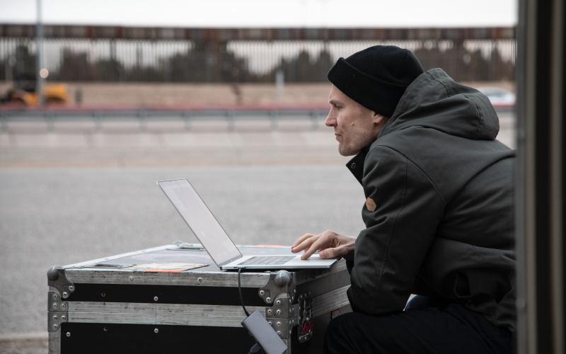 You can see Stephan Schulz sitting in front of a laptop. The laptop is standing on a black case.