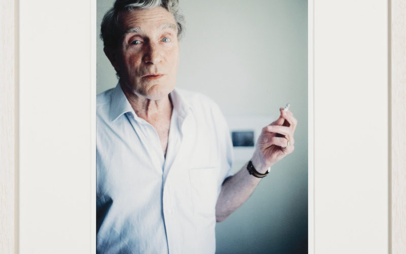 Same morning smoking, what looks like a regular cigarette. On Brion’s pinky his golden seal ring can be seen. Blurred in the background is the black-and-white photograph depicting Burroughs’ blackboard drawings illustrating his lecture The Four Horsemen of the Apocalypse, given at one of the Whole Earth Conferences a little outside of Aix-en- Provence, which also Brion did attend