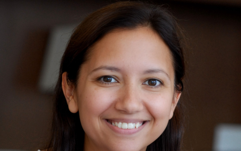 A smiling young woman with long black hair.