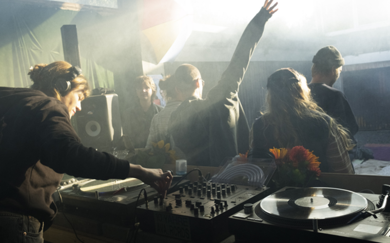 Mehrere Personen tanzen zu einem DJ-Set.