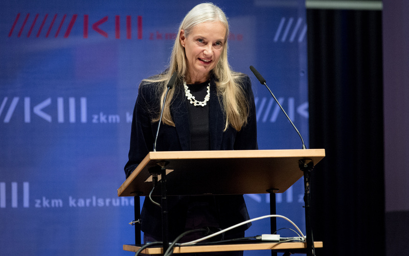 The photo shows Christiane Riedel at an exhibition opening.