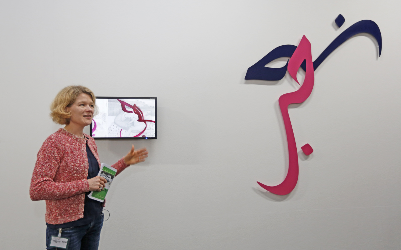 Eine Frau steht vor einem Kunstwerk