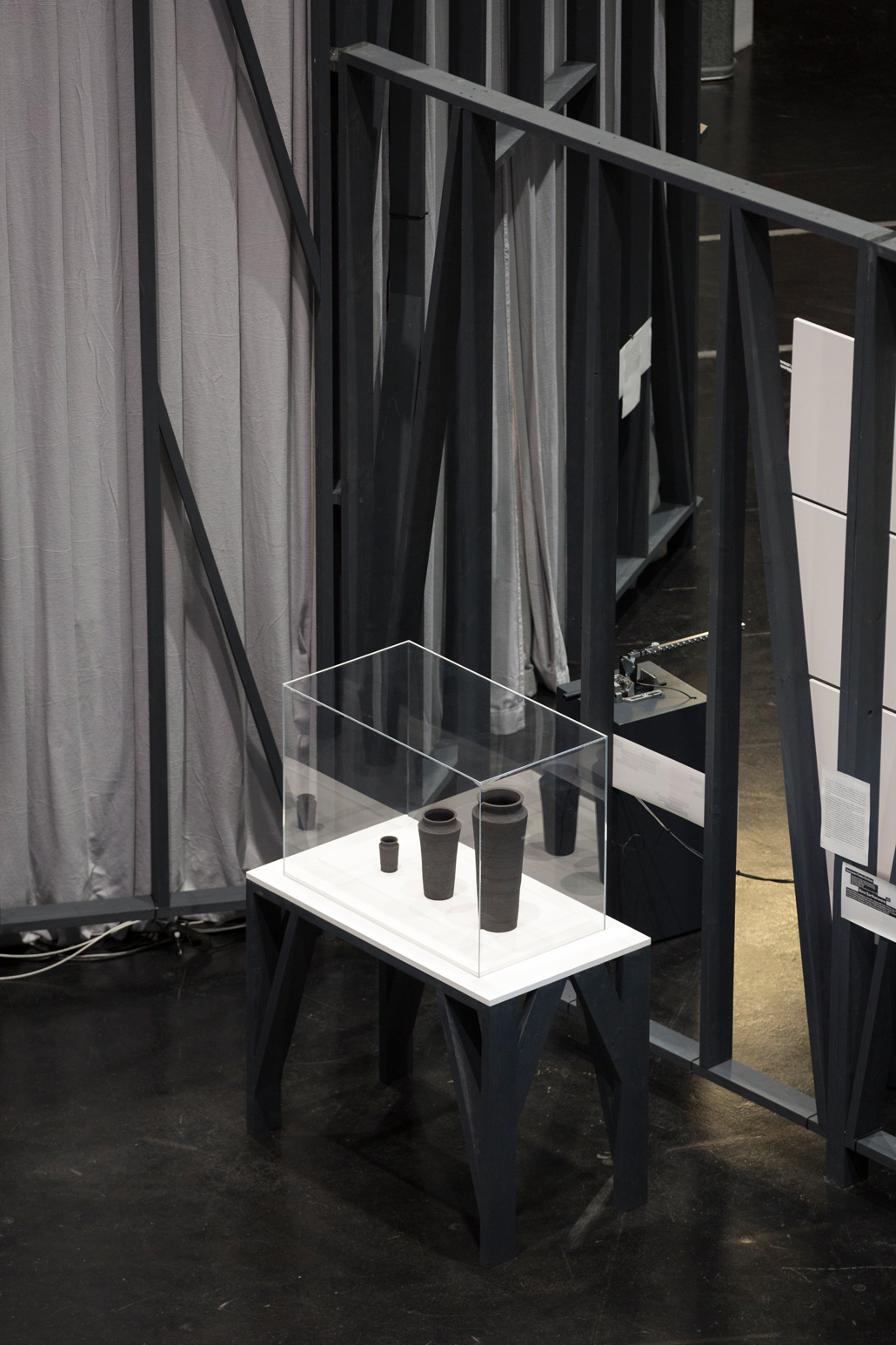 Three gray vases in different sizes in a showcase