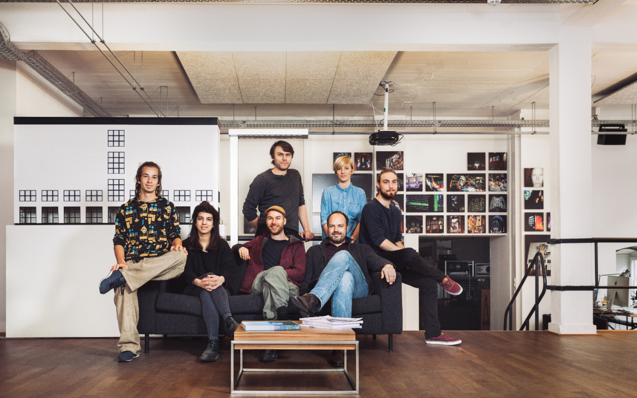 Das Künstlerkollektiv sitzt auf einem Sofa in ihrem Studio