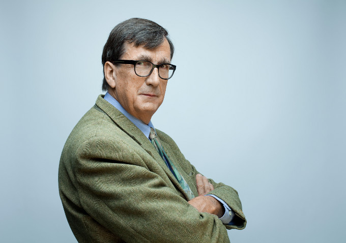 Ein Portrait von Bruno Latour. Er steht leicht seitlich zur Kamera, die Arme verschränkt.