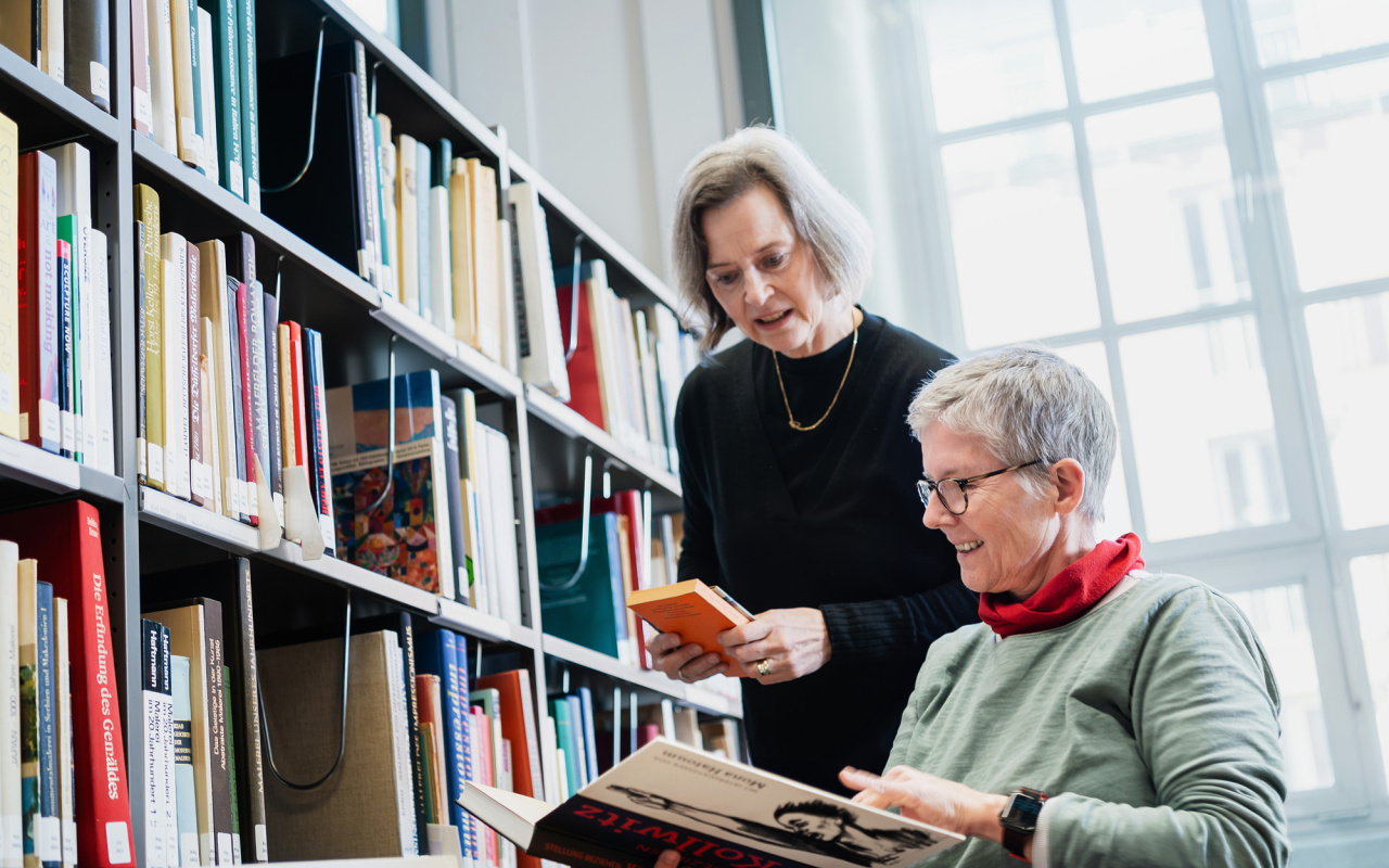 Zwei Frauen beim Einsortieren von Büchern.