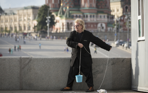 A man holding a cord with a blue bucket