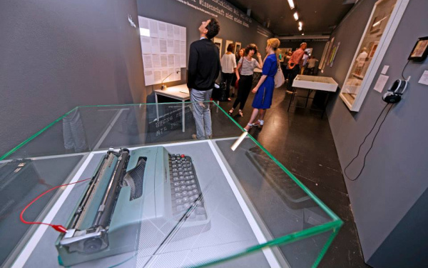 Menschen stehen im Ausstellungsraum und betrachten die Werke