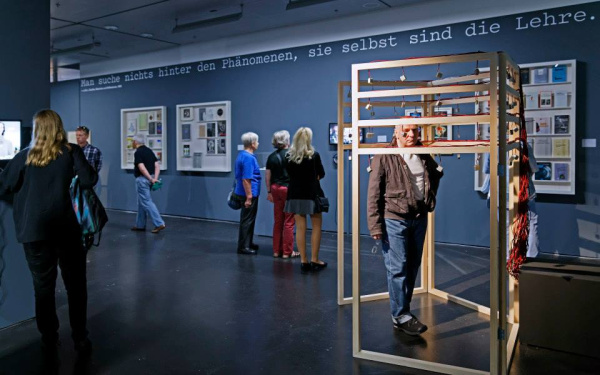 Menschen stehen im Ausstellungsraum und betrachten die Werke