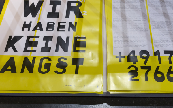 Ein gelb-weißes Transparent auf dem steht: "Wir haben keine Angst" und eine Telefonnummer