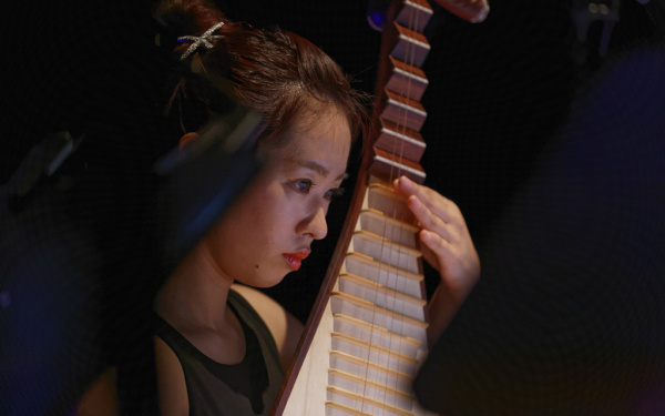 A woman at a plucked instrument