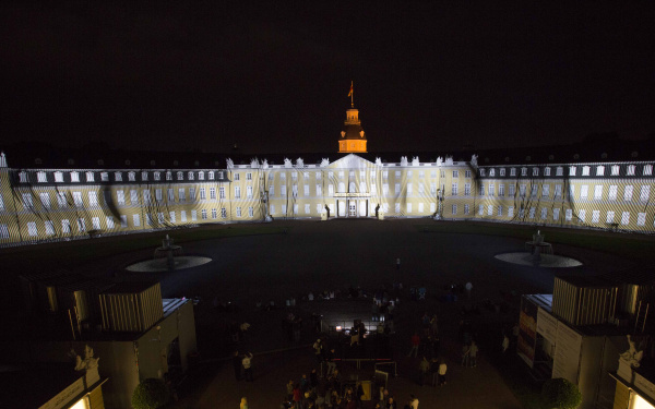Diagonale und runde, leuchtende Striche auf der Schlossfassade