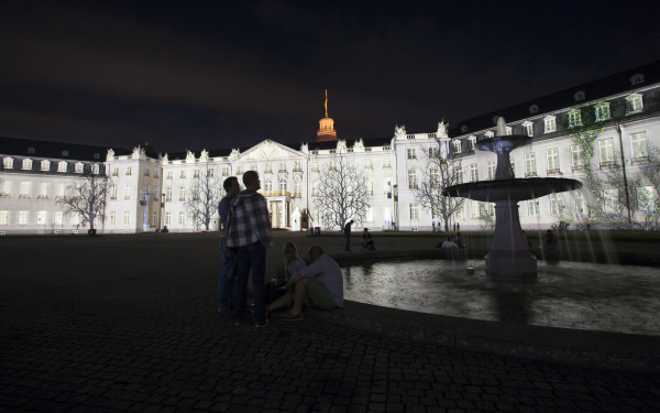 Die Schlossfassade in weißem Licht mit Schatten von Bäumen